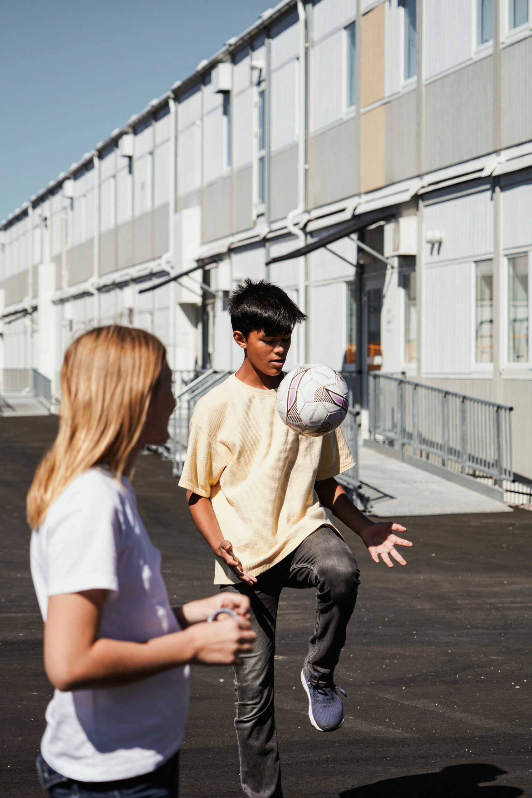 Elever leker på skolegård ved Nyckelbergskolen i Köping, med skolemoduler fra Expandia i bakgrunnen, trygg og aktiv uteområde for skolevirksomhet.