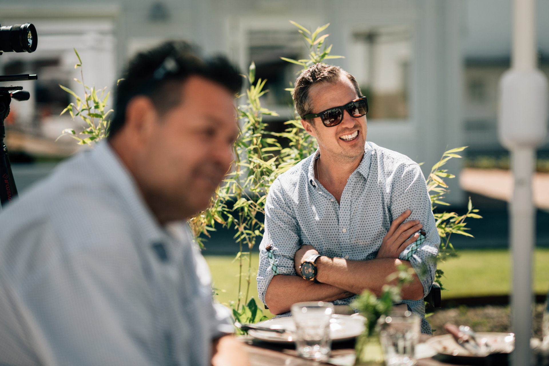 Slemmestad sentrum i Norge, to glade menn sitter ute i solen og drikker kaffe