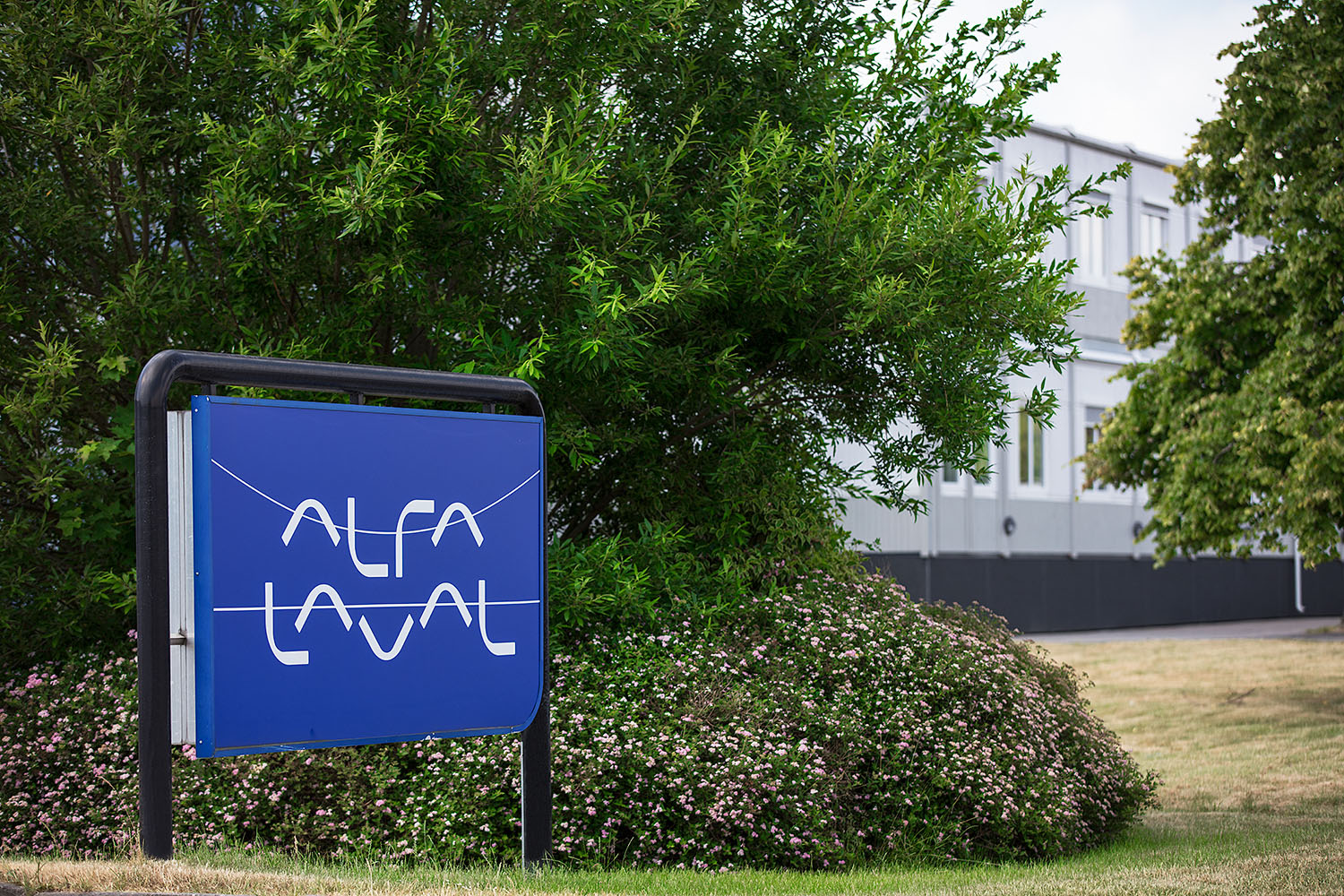 Tvåvånings kontorslösning från Expandia med ljusgrå fasad och jämnt placerade fönster, belägen i naturlig miljö med klippor.