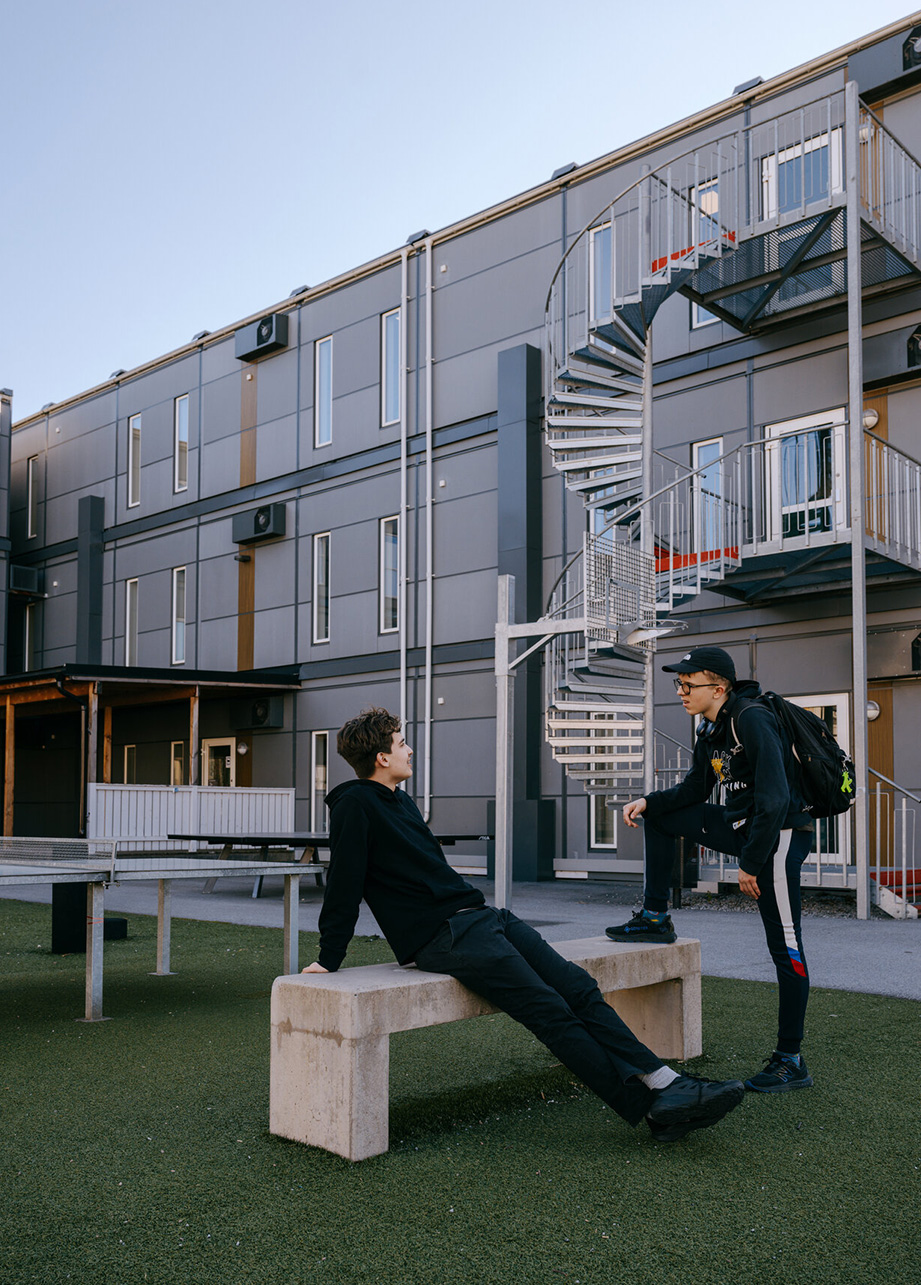 Elever samtaler utendørs på skolegården foran Expandias modulløsning på Ekens skole i Hammarby Sjöstad.