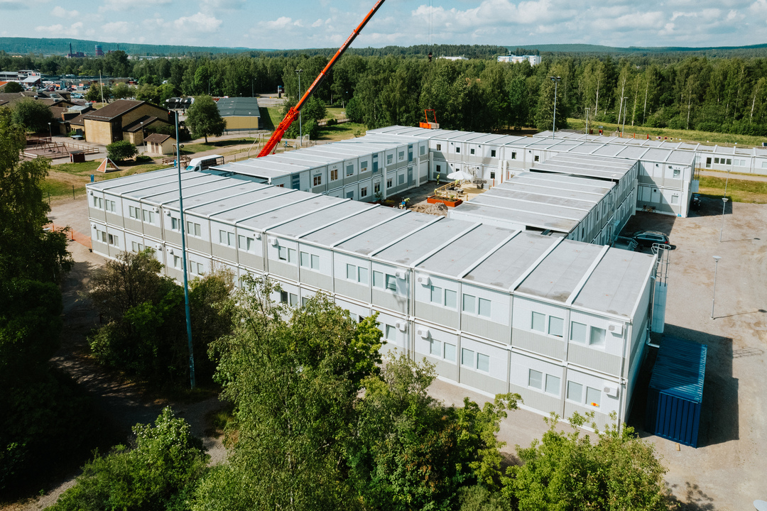 Dronebilde over Herrhagsgården omsorgs- og pleieboliger i Falun, bestående av en lys modulbygning i to etasjer. Boligen er bygget opp av sammenkoblede moduler og omgis av grøntområder. Modulløsningen leies fra Expandia.