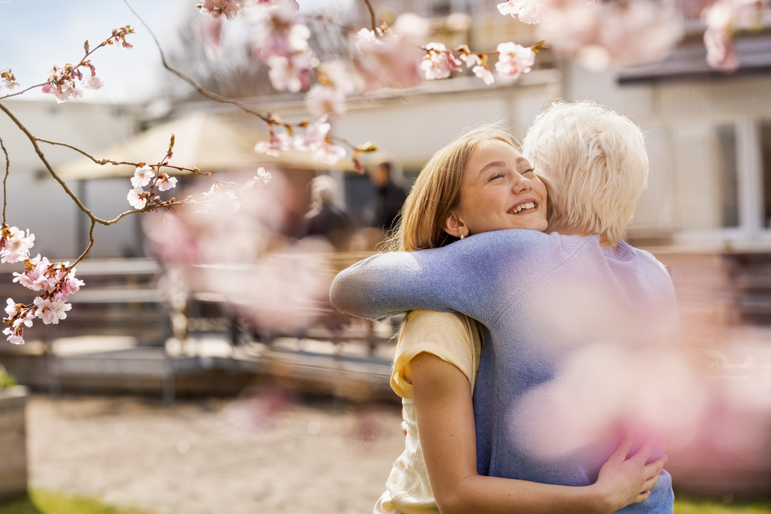 Eldre kvinne klemmer barnebarn