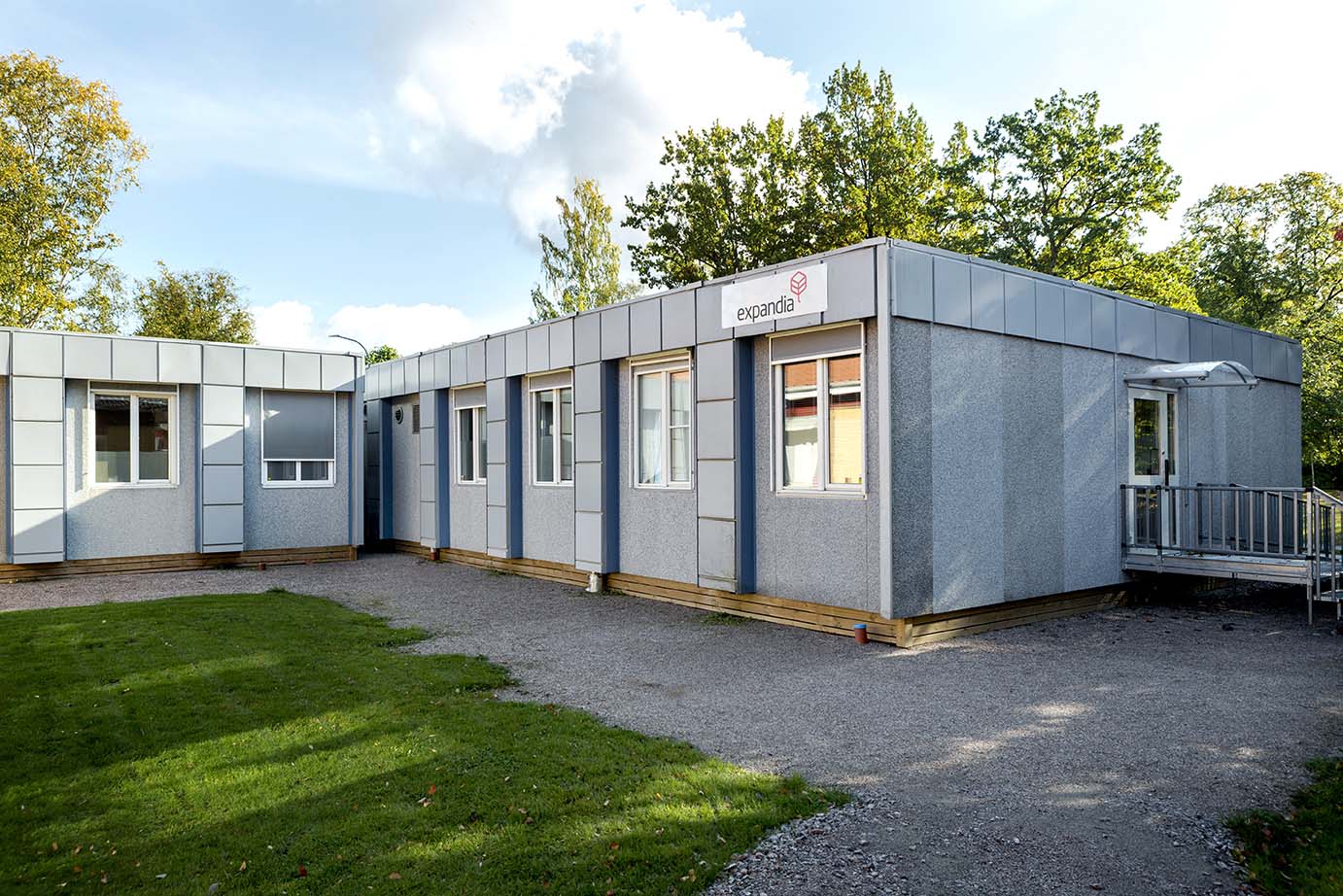 Eksteriør av Skebäcks helsesenter i Örebro, oppført med moduler fra Expandia. Inngang med rampe og vinduspartier omgis av grøntområde.
