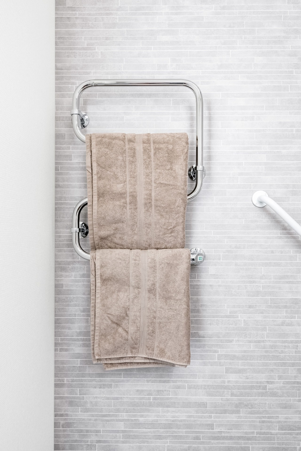 Praktisk och tillgänglig detalj i badrum – handdukstork i modulbaserad studentbostad i Visby från Expandia.