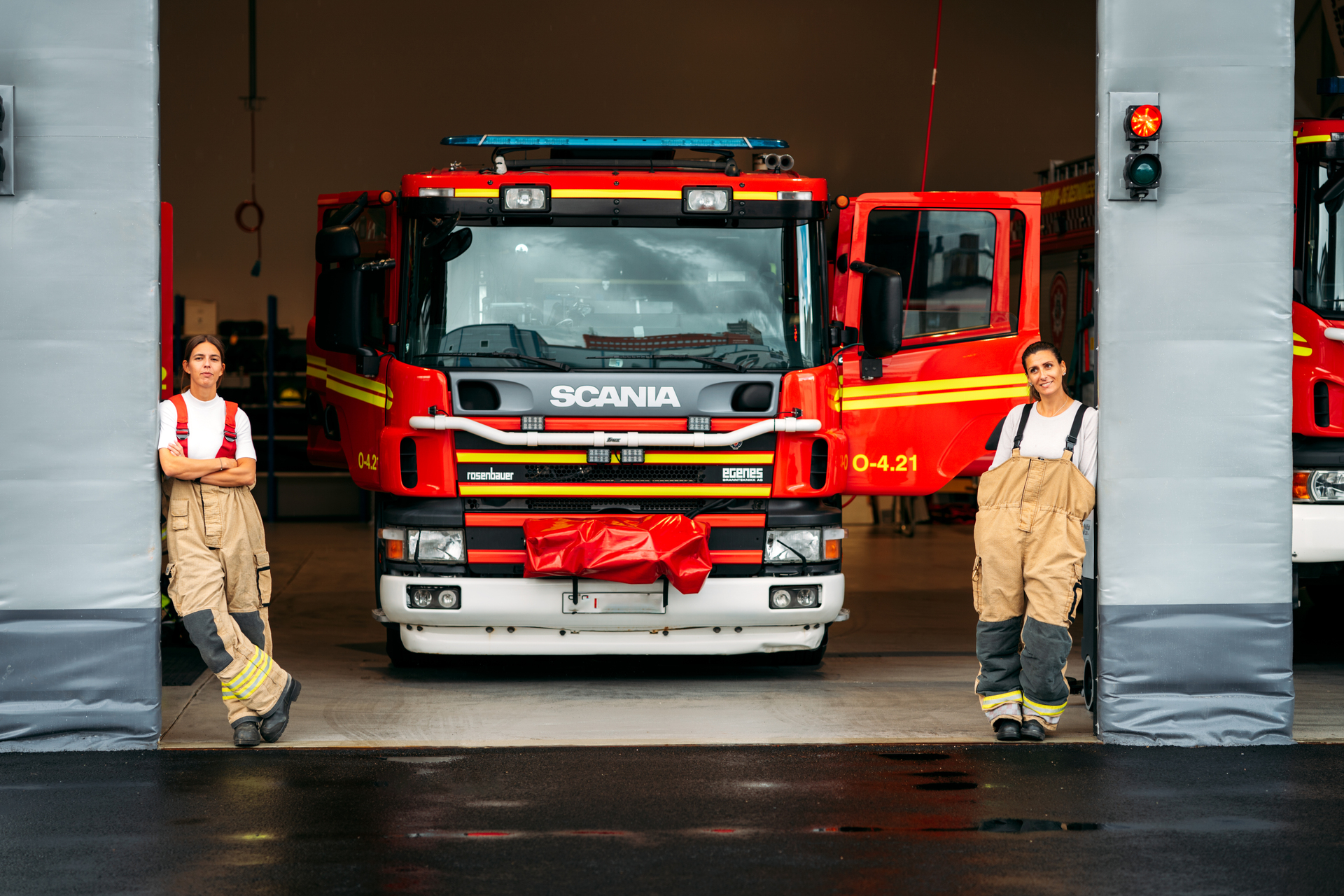 To brannmenn foran en bygning med brannbil